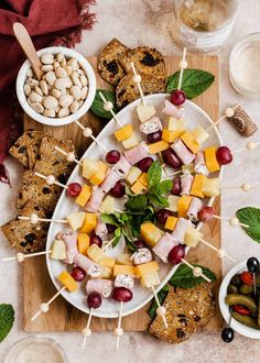 an assortment of appetizers on a platter with olives, grapes and nuts