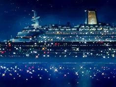 a large cruise ship in the ocean at night with stars on it's side