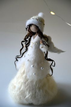 the doll is wearing a white dress and hat with long curly hair on it's head