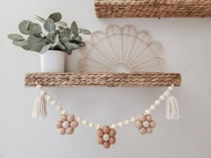 a shelf with some beads hanging from it and a potted plant next to it