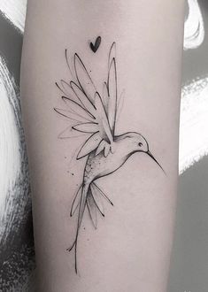 a black and white bird tattoo on the right thigh, with a heart in the background