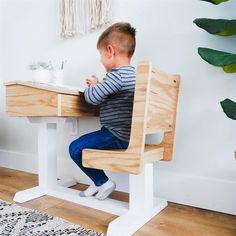 a little boy sitting at a wooden table