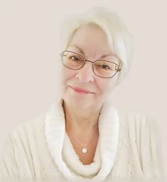 an older woman wearing glasses and a white sweater