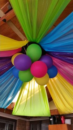 colorful balloons are hanging from the ceiling in a room