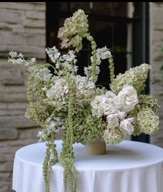 two vases filled with white flowers sitting on top of a table