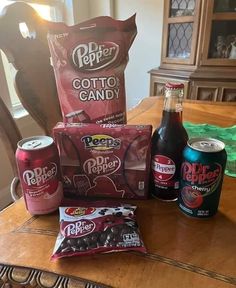 the table is covered with various snacks and drinks, along with two bottles of soda