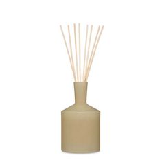 a white vase with reeds in it on a white background