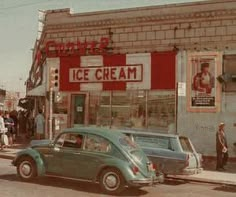 an old photo of cars parked in front of a ice cream shop