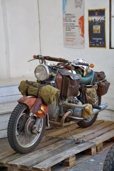 an old motorcycle sitting on top of a wooden pallet