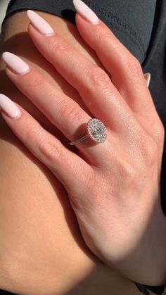 a woman's hand with white manicured nails and a ring on her finger