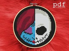 a cross stitch skull with red hair and blue eyes on a red fur background, in the shape of a circle