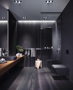 a bathroom with black walls and wooden floors