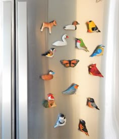 magnets on the side of a refrigerator with birds and other animals attached to it