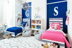 two beds in a room with blue walls and white rugs on the floor next to each other