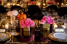 the table is set with flowers, candles and place settings for an elegant dinner party