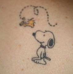 a drawing of a dog on the back of a person's shoulder with a small bird flying above it