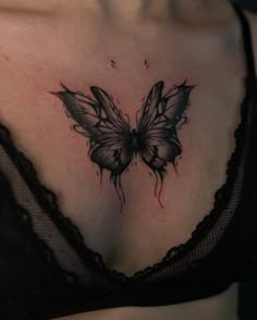 a close up of a woman's chest with a butterfly tattoo on her chest