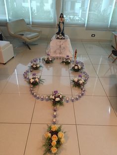 a table topped with flowers and candles on top of a white tiled floor next to a window