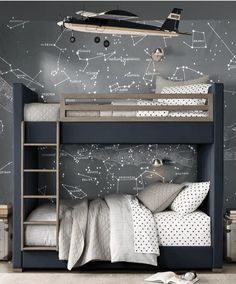 a bedroom with a bunk bed and space map wallpaper on the walls behind it