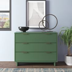 a green dresser sitting next to a potted plant