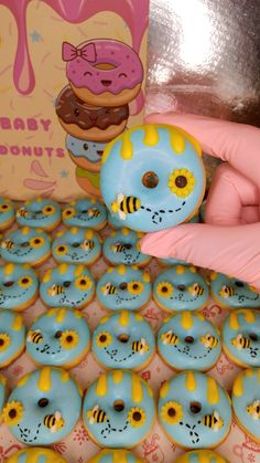 a person holding a doughnut in front of a box of donuts