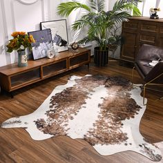 a living room with a cowhide rug on the floor next to a brown chair