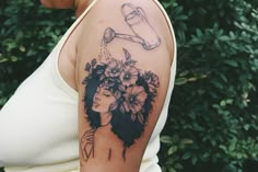 a woman with flowers on her shoulder has a tattoo