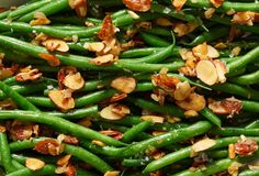 green beans with almonds and seasoning in a white bowl