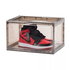 a pair of red and black sneakers in a clear box