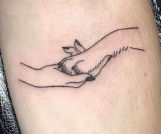 a hand holding a dove tattoo on the ankle