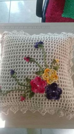 an embroidered pillow with flowers on it