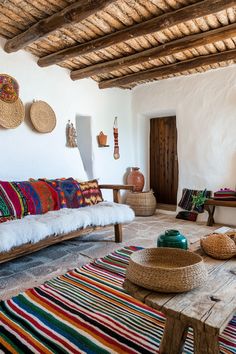 a living room filled with lots of furniture and rugs on top of a wooden floor