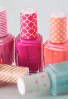 several different colored nail polishes on a white surface with polka dots and pinks