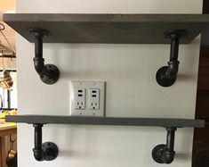 two electrical outlets are attached to the wall above a shelf with pipes and plugs