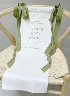 a white chair with a green ribbon tied to it's back and the words, father of the bride