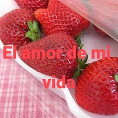 four strawberries in a container with the words el anor de mi vida written below them