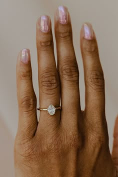 a woman's hand with a diamond ring on it