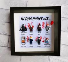 a shadow frame with the words in this house we are surrounded by handprinted characters