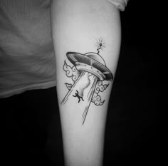 a black and white photo of a tattoo with an alien spaceship flying through the sky