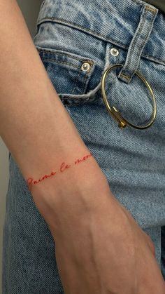 a woman's arm with a small tattoo on it that reads, i love you