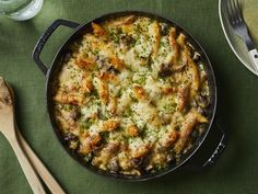 a casserole dish with cheese and meat in it on a green tablecloth