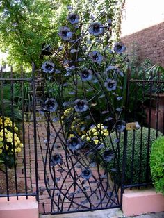 an iron gate with blue flowers on it