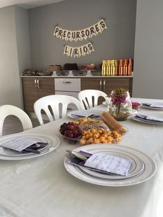 a table set with plates, silverware and wine bottles for a party or brunch