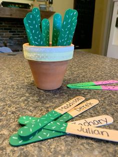 a potted cactus sitting on top of a kitchen counter next to wooden name tags