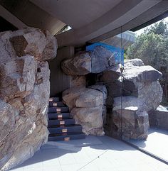 there is a large pile of rocks in front of the entrance to a building that has stairs leading up to it