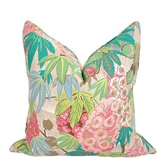 a pink and green floral pillow on a white background