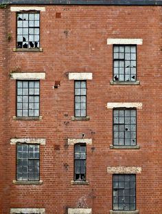 an old red brick building with broken windows