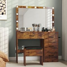 a bedroom with a vanity, mirror and lights on it's side table in front of a bed