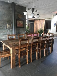 a dining room table and chairs in front of a brick wall with lights on it