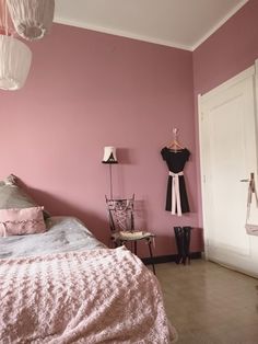 a bedroom with pink walls and flooring is pictured in this image, there are two lamps on either side of the bed